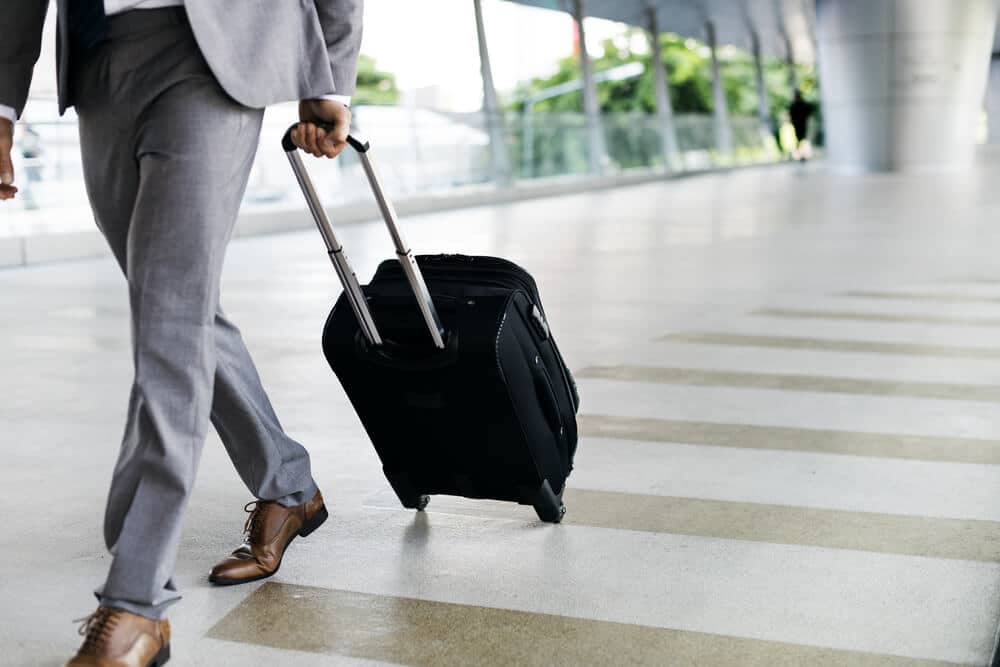 homem de terno andando com mochila para viagens
