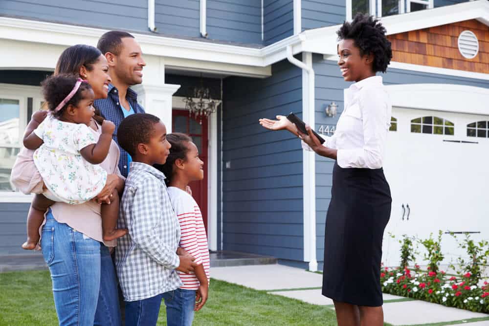 mulher apresentando casa para uma família