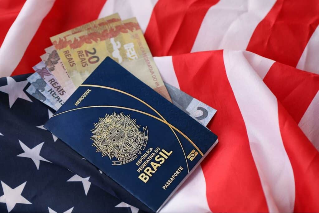 foto do passaporte brasileira com cédulas atrás e uma bandeira dos EUA atrás
