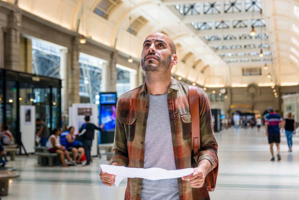 Homem olhando para tabelas de preço em estação de metrô em Dubai