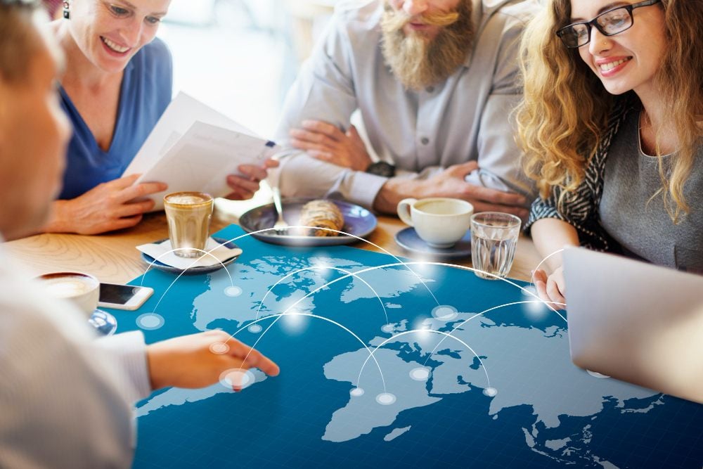Pessoas comendo ao redor de uma mesa e conversando sobre abrir uma empresa offshore