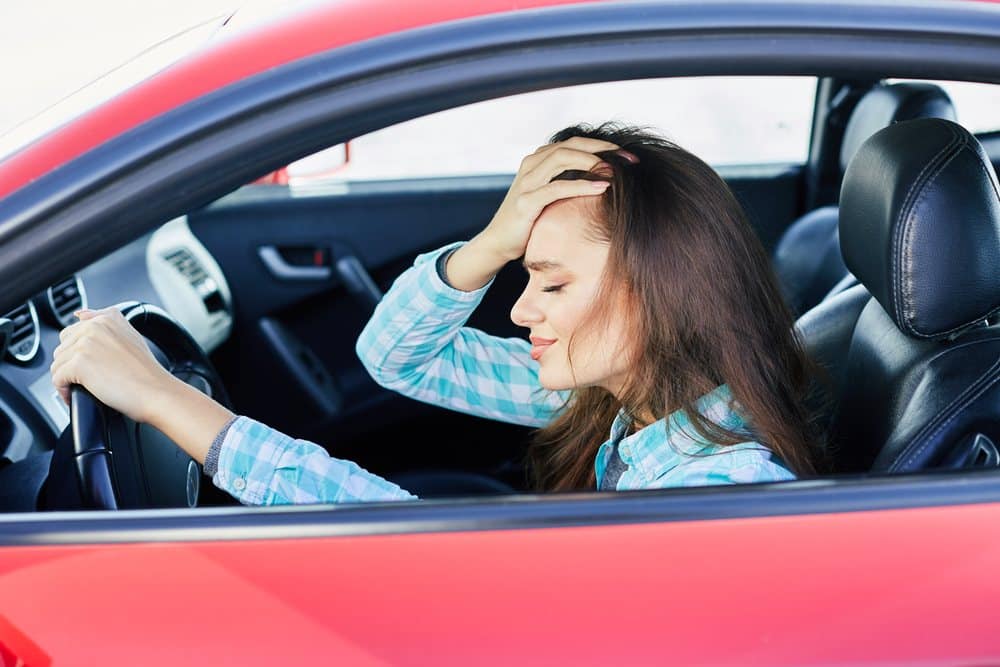 Mulher dirigindo com medo porque está sem carteira de motorista nos EUA