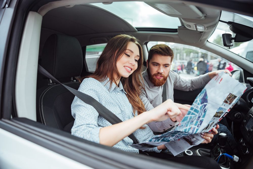 Casal com carteira de motorista nos EUA com um mapa dirigindo pelo país