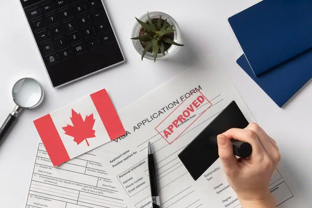 Pessoa carimbando documento com a palavra aprovado em inglês para saber como morar no canada