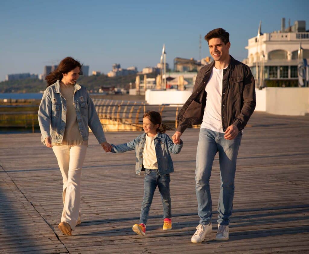 Família caminhando no Porto de Lisboa, clima ensolarado